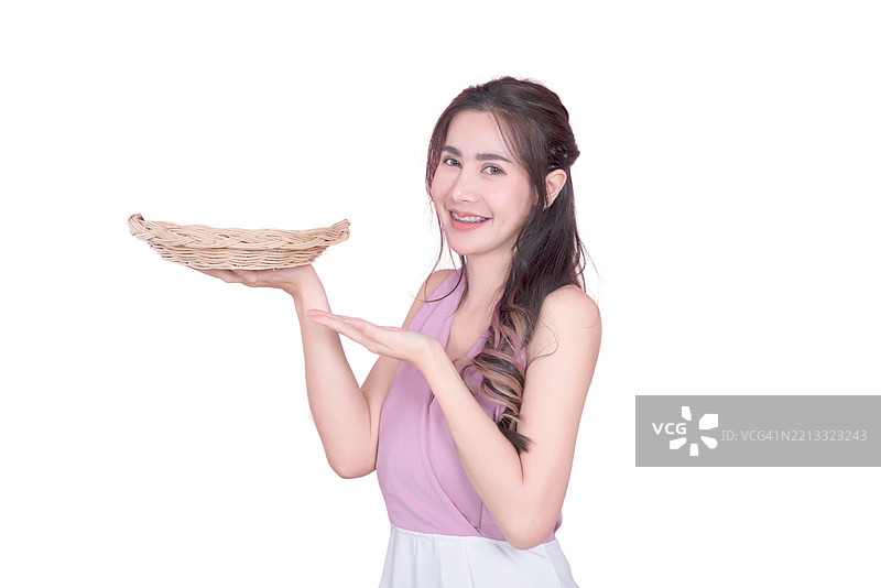 一位女性手持食物篮，面带微笑。图片素材