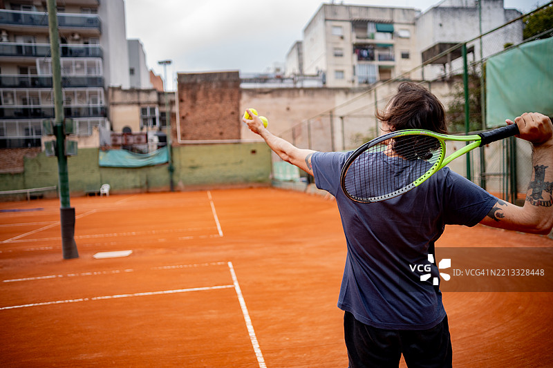 网球运动员在红土网球场准备发球图片素材