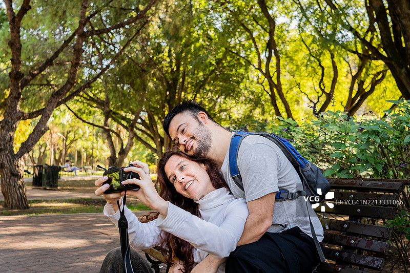 情侣在公园里用相机自拍图片素材