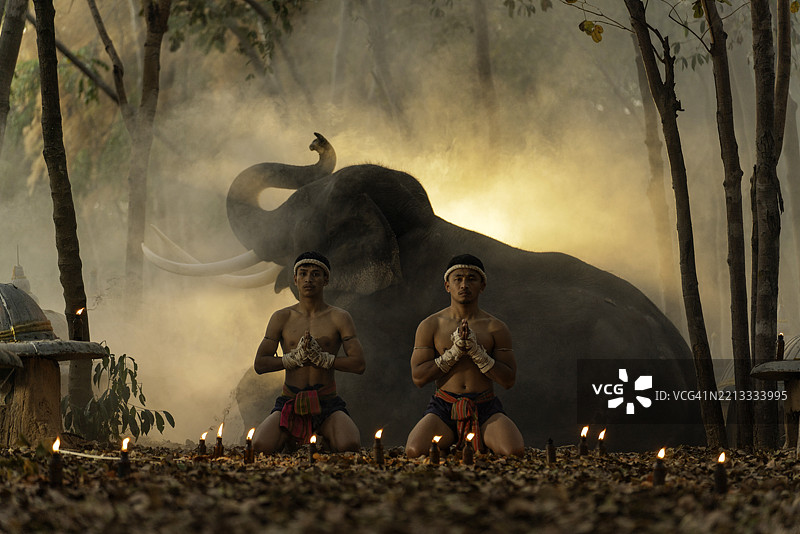 黄昏时分，泰拳拳手在森林中与大象进行仪式图片素材