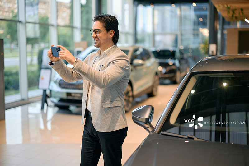 商人在展厅拍摄新车的照片图片素材
