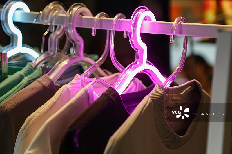 当地街市，五彩缤纷的针织毛衣挂在霓虹色的衣架上图片素材