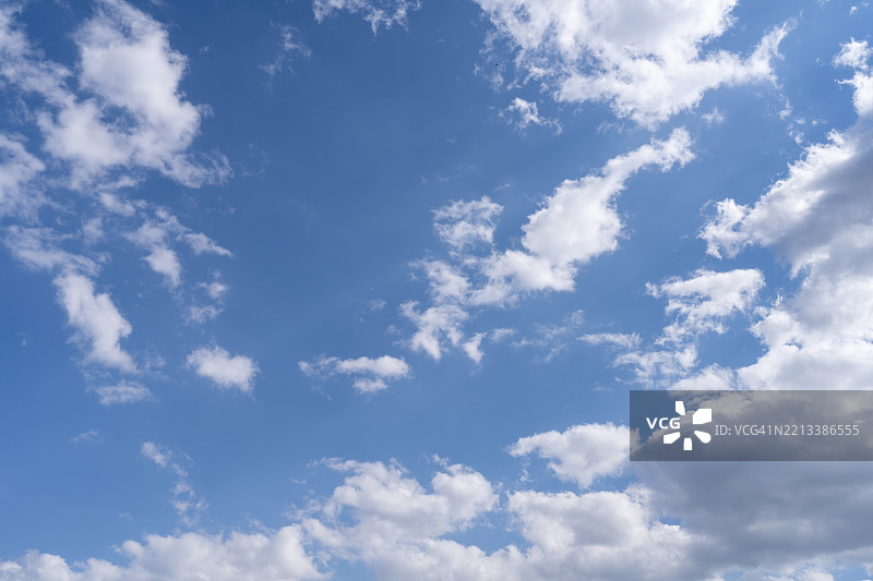 晴朗的蓝天，点缀着零星的白云，宁静而令人振奋的氛围图片素材