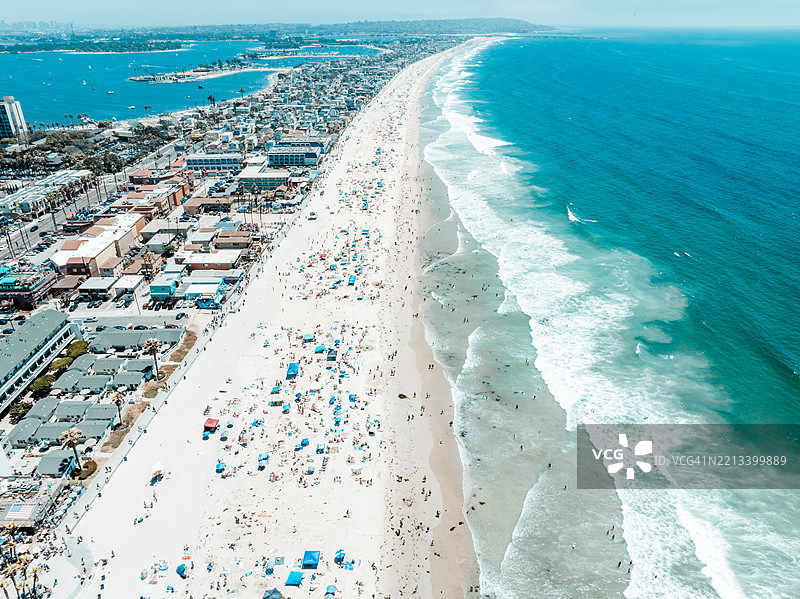 阳光明媚的七月四日，繁忙的太平洋海滩和沿海城市的鸟瞰图。图片素材