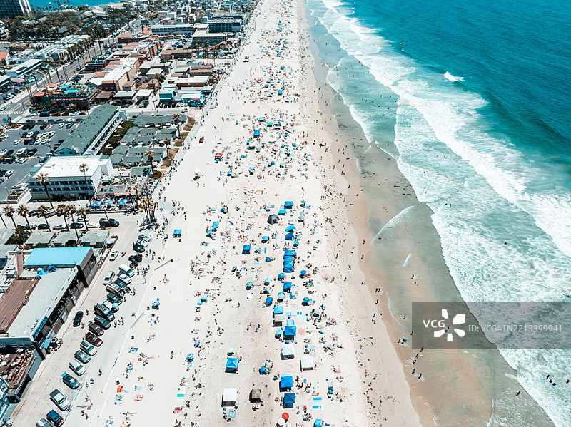 阳光明媚的七月四日，拥挤的太平洋海滩和沿海城市的鸟瞰图。图片素材