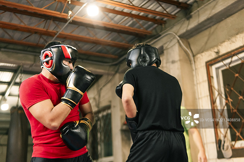 两名年轻拳击手在健身房的拳击课上进行对练图片素材