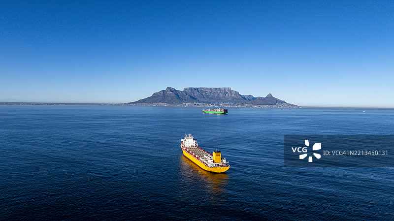 明亮的黄色甲板货船驶向开普敦港图片素材