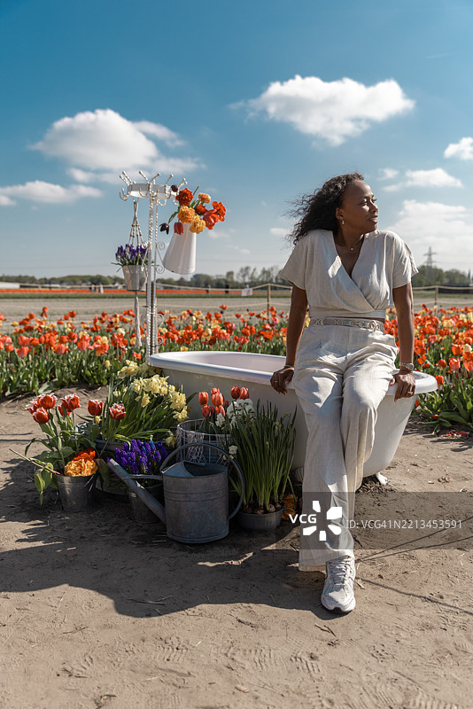 一位美丽的多元文化女性游客在郁金香花田中图片素材