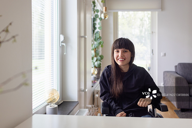 微笑的神经多样性少女坐在轮椅上肖像图片素材