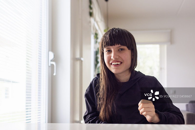 微笑的神经多样性少女坐在轮椅上肖像图片素材