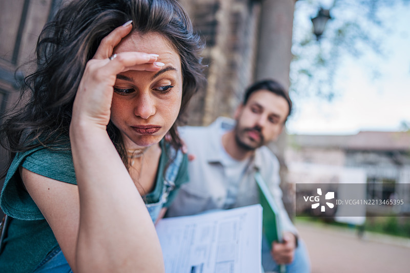 担心的大学生在户外接到同学的坏消息图片素材