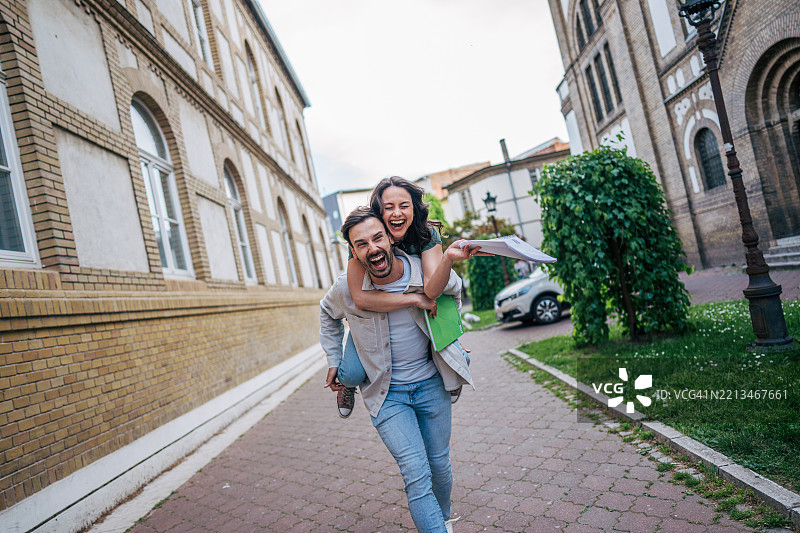 快乐的学生们在大学校园里奔跑，庆祝考试通过。图片素材