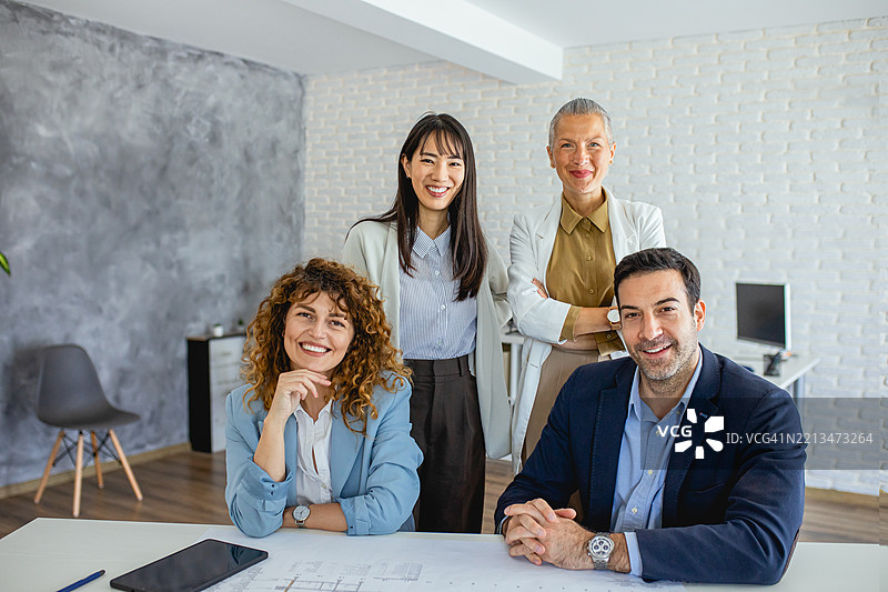 自信的商务团队在现代办公室工作室中合影，面向镜头。图片素材