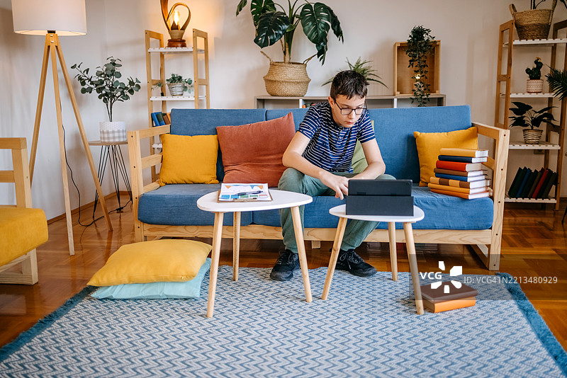 年轻的少年在家用平板电脑学习图片素材