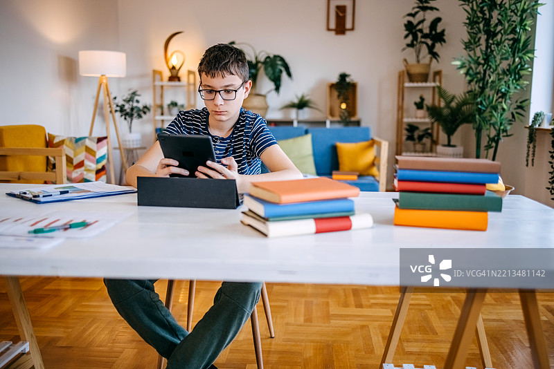 年轻的少年在家用平板电脑学习图片素材