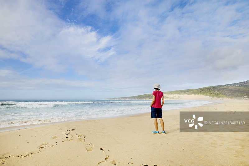 一位女性站在海边的理想沙滩上图片素材