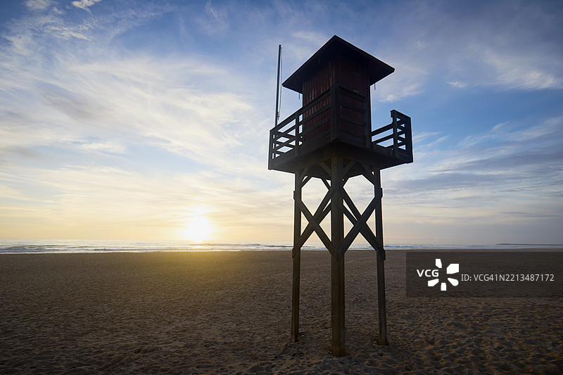 海滩和海洋上的救生塔在日落时分图片素材