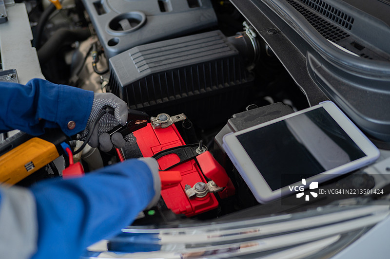 特写手握电池测试工具以测试车辆电池状态的库存照片图片素材