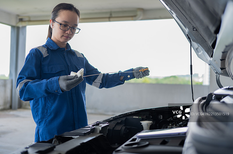 亚洲华裔女性机械师打开发动机油盖检查并确保其处于良好状态的库存照片图片素材