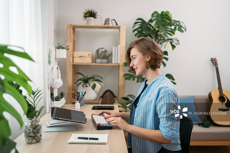微笑的年轻女性在家中使用人工智能技术进行高效远程工作图片素材