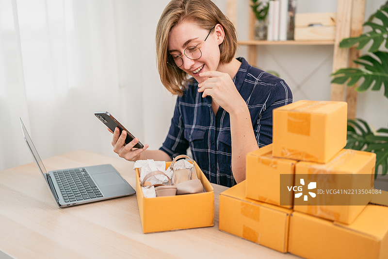 快乐的在线卖家在家检查产品图片素材