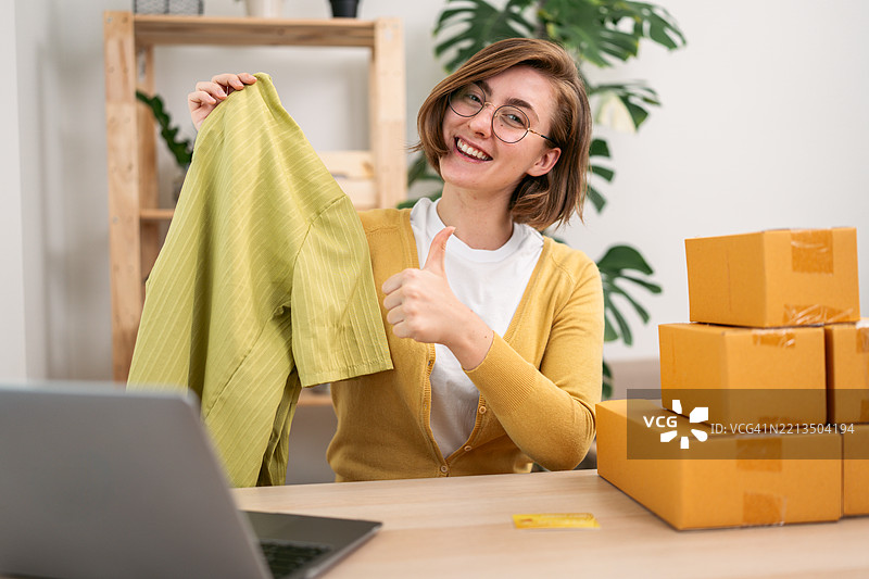 满意的企业家在家成功地在线销售服装图片素材