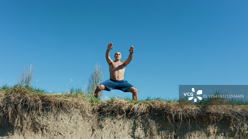 成熟男性在阳光明媚的日子里户外练习马步图片素材