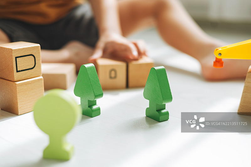 儿童游戏：明亮的表面上有木块和绿色树木，激发想象力图片素材