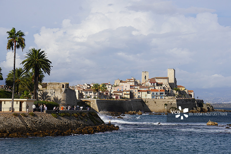 阳光下的法国安提布的棕榈树、堡垒和古老的防御工事图片素材