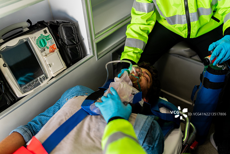 年轻男性受害者在救护车中接受医护人员的帮助图片素材