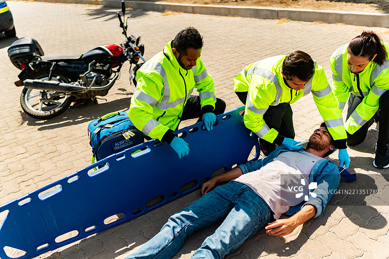 急救人员将年轻受害者放上城市街道的医院担架图片素材