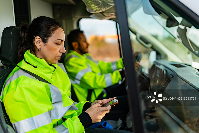 中年女急救员在救护车内使用手机图片素材