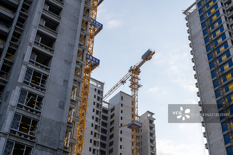 建筑工地上高耸的起重机和未完工的建筑物图片素材