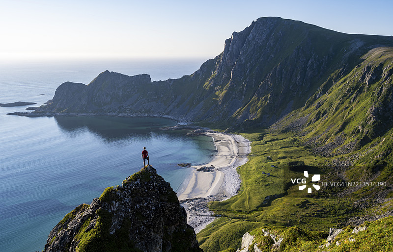 攀岩者在岩石上,俯瞰如画的海岸风景,陡峭的海岸与Måtind或Måtinden峰,Høyvika海滩和海洋,徒步登顶Måtind,安多亚岛,维斯特兰,诺尔兰,挪威,欧洲图片素材