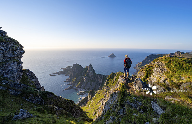 登山者在Måtind或Måtinden的山顶,俯瞰迷人的海岸风景、岩石海岸和海洋,安多亚岛,维斯特罗伦,诺尔兰,挪威,欧洲图片素材