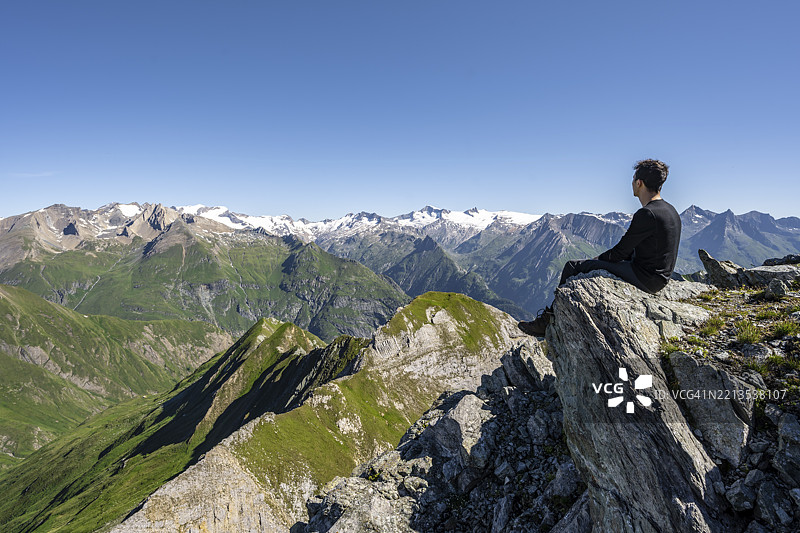 登山者坐在岩石上，面前是格罗斯维尼迪格山的全景，维尼迪格山脉的山峰，来自戈斯莱斯旺德峰的视角，拉索尔林山脉，霍赫陶恩国家公园，东蒂罗尔，蒂罗尔，奥地利图片素材