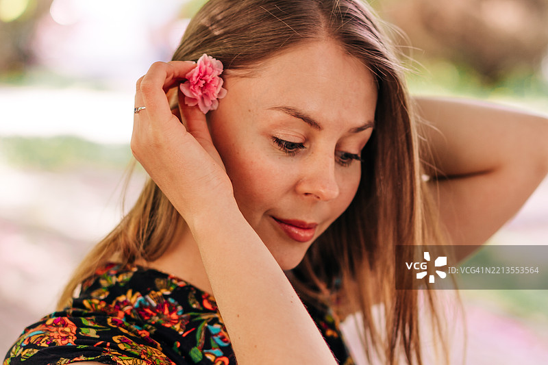 美丽的女人在宁静的花园中手捧鲜花图片素材