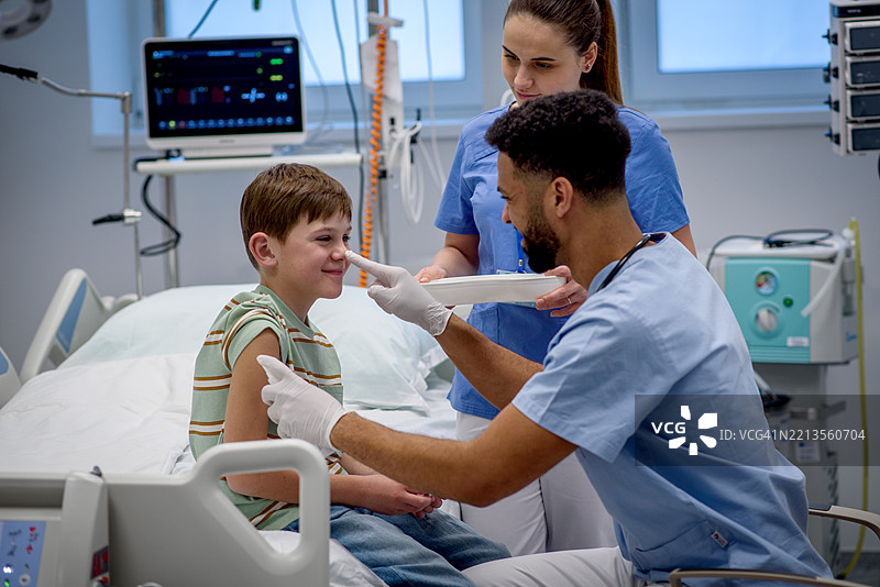 医生在给男孩接种疫苗前清洁皮肤。儿童免疫接种。图片素材