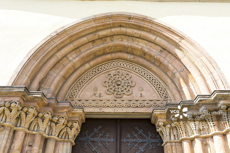 德国萨克森州诺森镇教堂南门的晚罗曼式框架三角楣上的环形编织带装饰图片素材