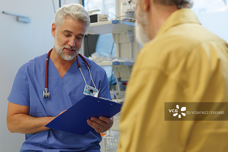 成熟的医生正在与老年患者咨询。图片素材