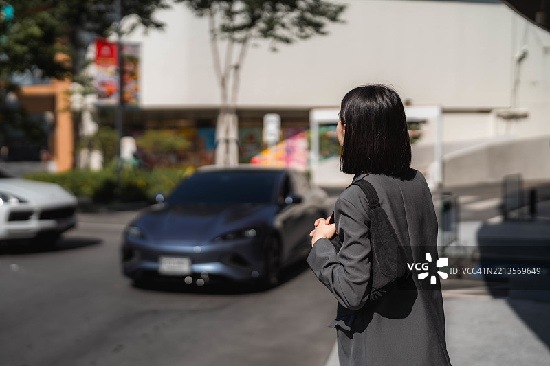 女商人与同事们一起进入电动车，准备通勤上班。图片素材