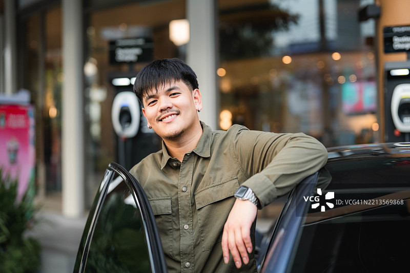 微笑的司机站在打开的车门旁图片素材