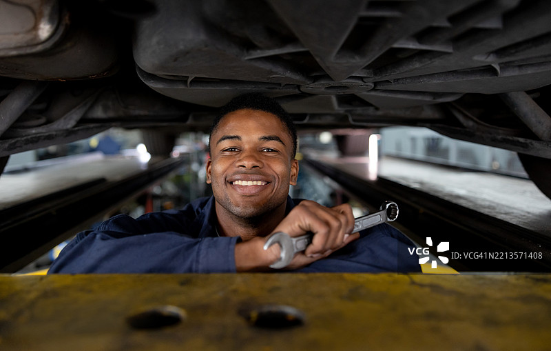 机械师在车库里修车，显得非常开心图片素材