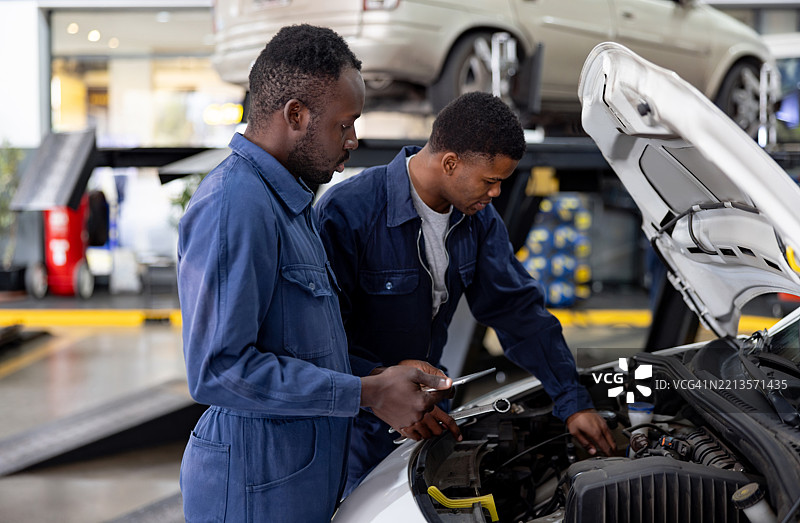 机械师在汽车修理店修理汽车图片素材