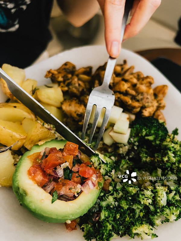 第一人称视角，双手熟练地使用餐具，享受一顿健康均衡的餐点。图片素材