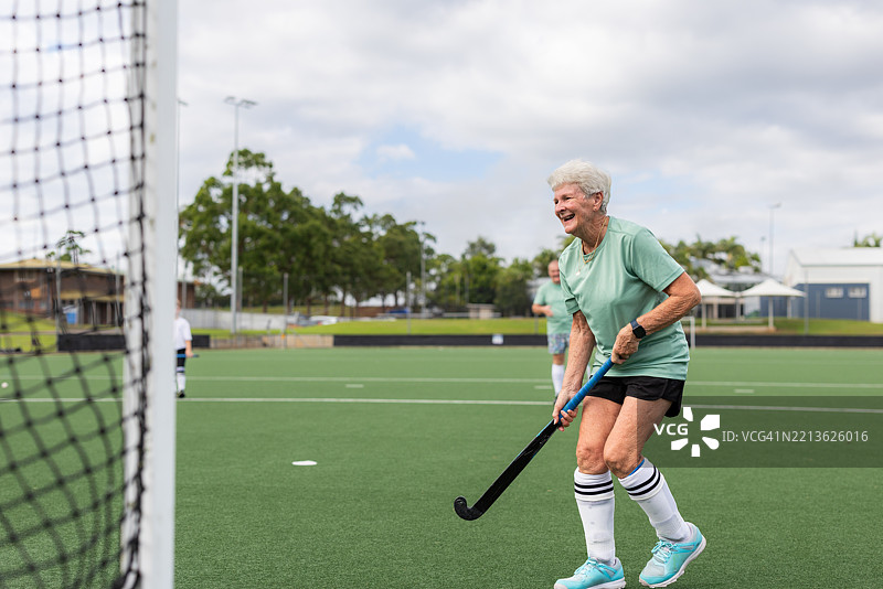 快乐的老年女性曲棍球运动员在训练中图片素材