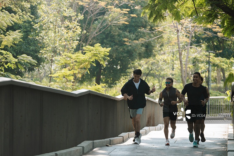 一群男性跑步者在公园里一起慢跑，参加他们的常规俱乐部活动图片素材
