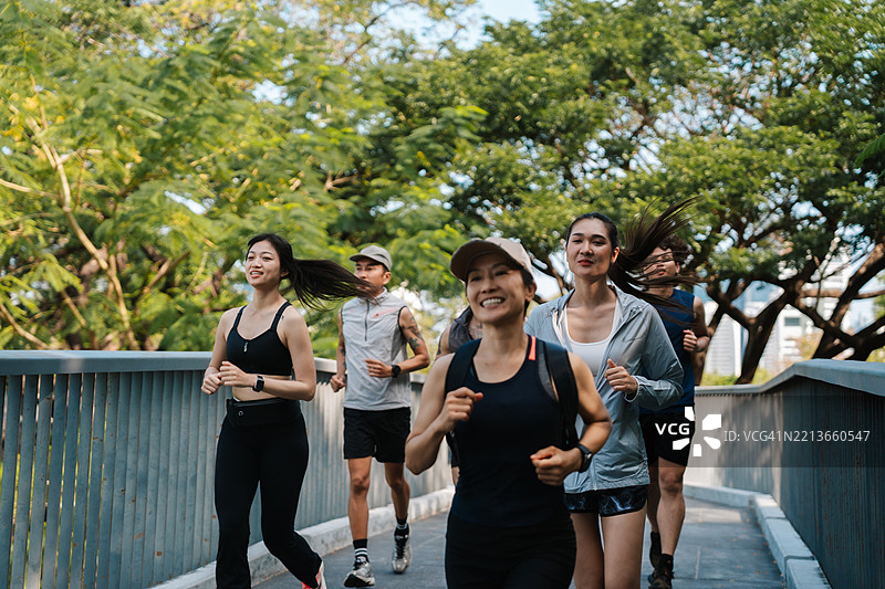 一群跑步者在公园里一起慢跑，参加他们的常规俱乐部活动图片素材