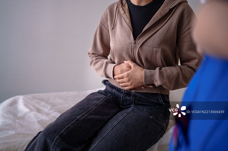 患者捂着腹部，表示不适图片素材