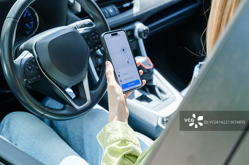 女性在丰田车内使用智能手机上的GPS应用程序图片素材